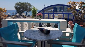 Eine Terrasse mit Tisch, Stühlen und Meerblick.