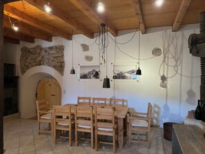 Un comedor con muebles de madera, una pared de piedra y una puerta de madera con la leyenda 'Eintracht Frankfurt'.