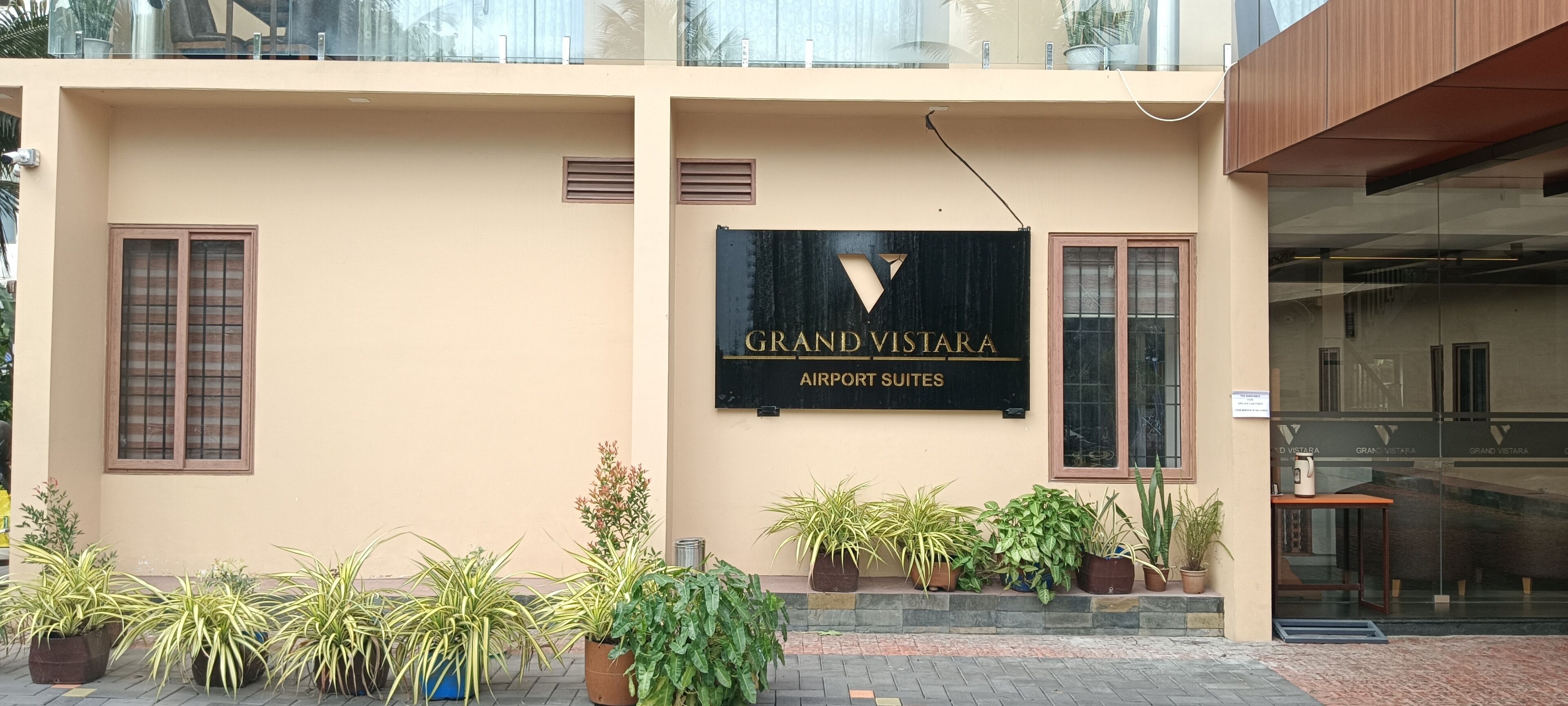A building with a sign reading 'GRAND VISTARA AIRPORT SUITES.'