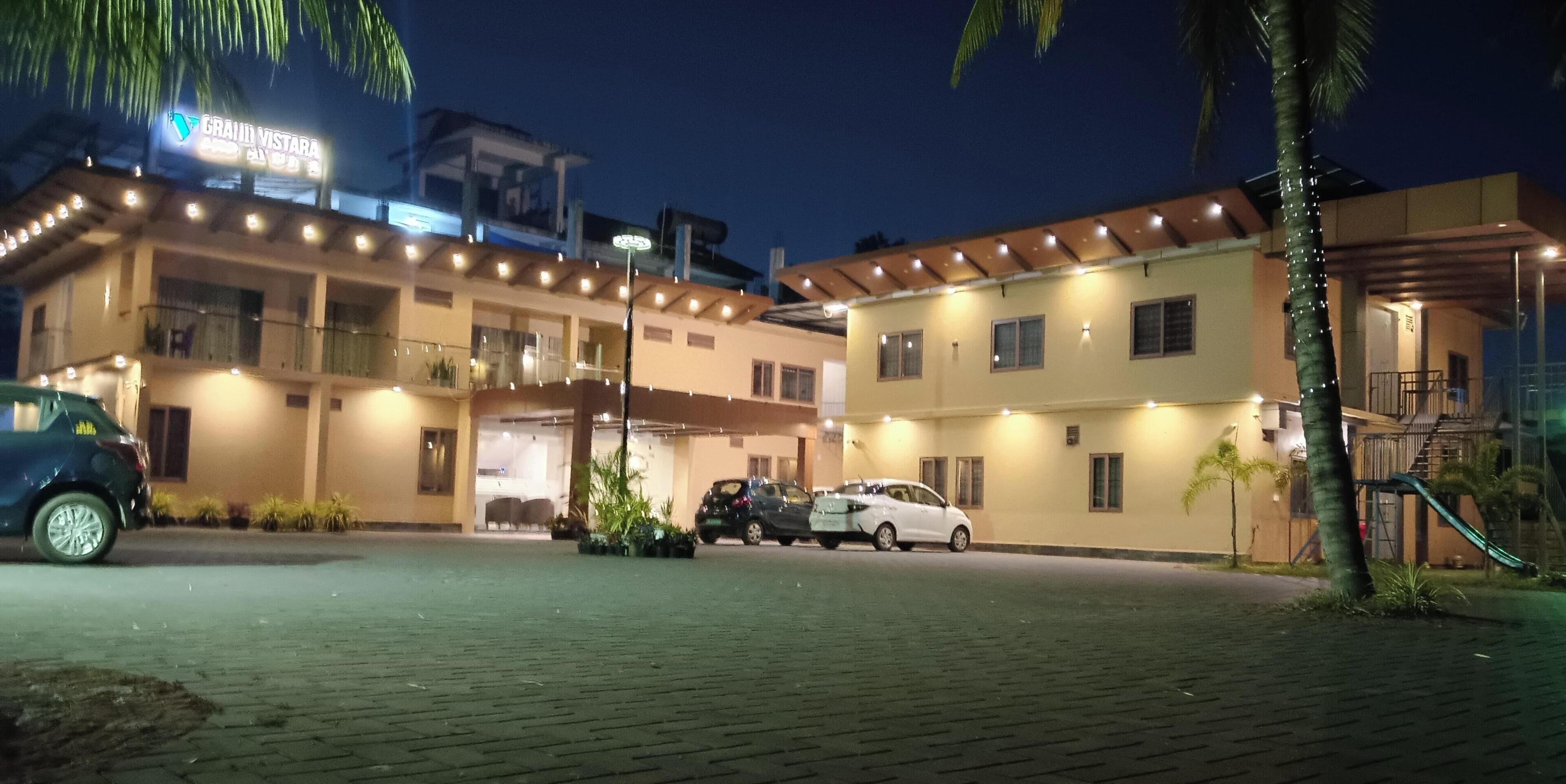 Een hotel met een goed verlichte ingang, een overdekte parkeerplaats en een duidelijk zichtbaar bord.