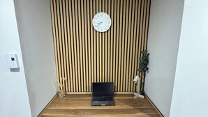 Et moderne værelse med skråt skrivebord, et ur og en bærbar computer.