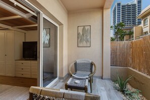 A balcony with a TV, a chair, and a dining table. - Scandinavian Loft Escape in JVC Dubai (Dubai)
