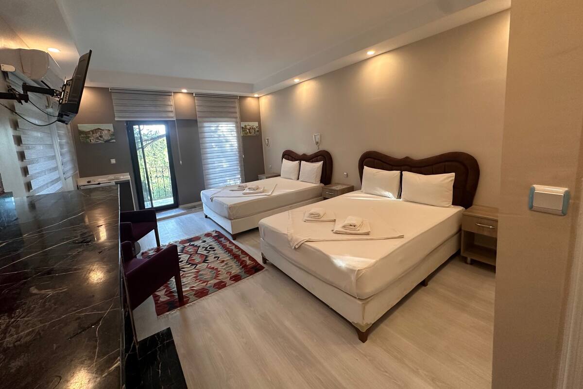 Une chambre d’hôtel avec deux lits, un comptoir en marbre et une vue sur l’extérieur.