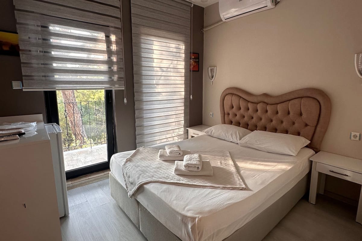 Une chambre à coucher comprenant un lit, une table de chevet, une commode et un appareil de climatisation.