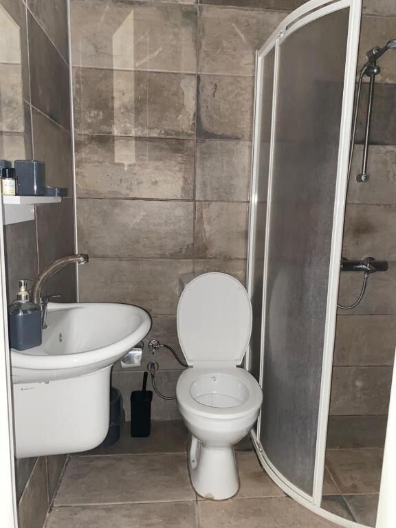 Un baño con inodoro, lavabo y cabina de ducha.