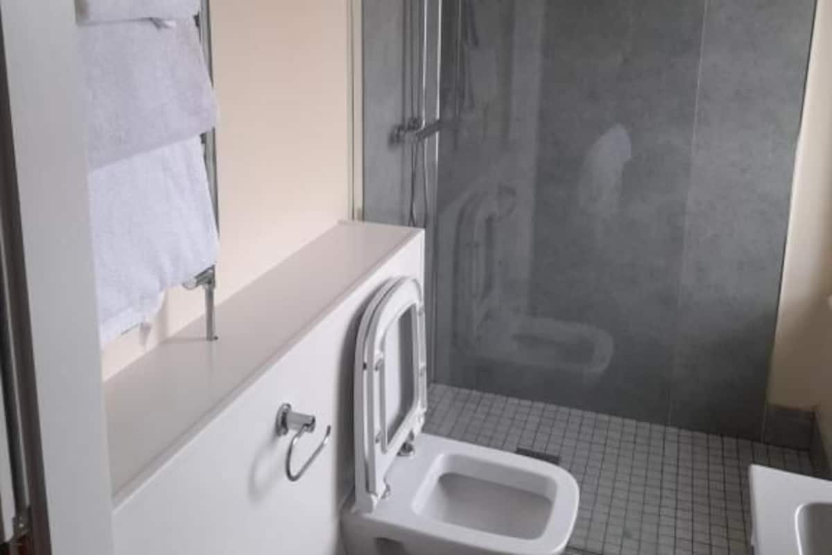 A bathroom with a shower, toilet, and sink.
