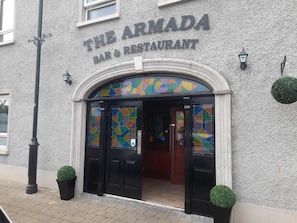 LâArmada, bar et restaurant, se distingue par sa façade Ă motifs, ses portes dâentrĂ©e noires et sa vitrine colorĂ©e en verre teintĂ©.