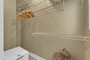 A laundry area with a metal drying rack, a wicker basket, and a white appliance. - Olde Walkerville Wonder! (Windsor)