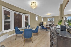 A modern kitchen with a round glass table, blue chairs, and a decorative bar counter. - Olde Walkerville Wonder! (Windsor)