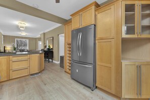 A kitchen with wooden cabinets, a stainless steel refrigerator, and a built-in oven. - Olde Walkerville Wonder! (Windsor)