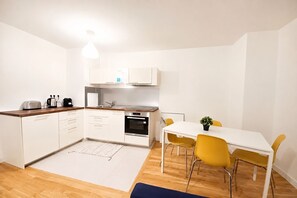 A compact kitchen with white cabinets, a toaster, a kettle, and a sink. - Elegancia Rueil, 20 min de Paris La Défense, quartier recherché, Lac (Rueil-Malmaison)