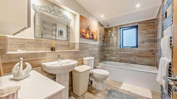 A modern bathroom with a sink, toilet, and shower.