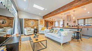 A spacious living area with a sofa, coffee table, and a kitchen in the background.