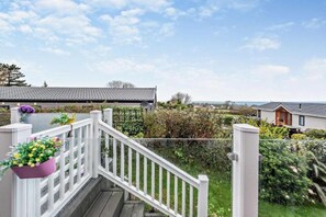 Un quartier résidentiel avec une balustrade blanche, un jardin et des maisons en arrière-plan.