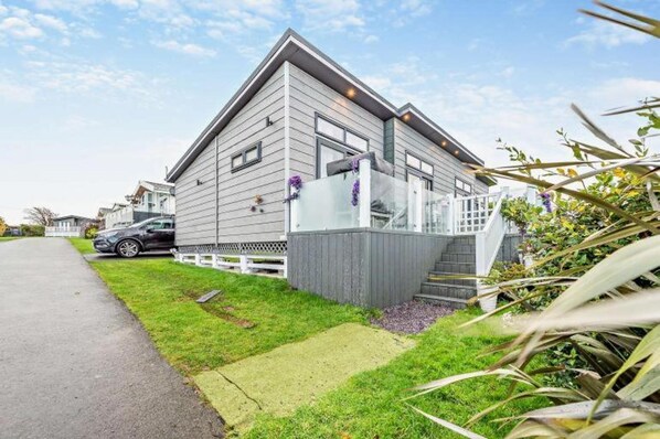 Une maison à deux étages avec un porche à l’avant, une allée et une pelouse bien entretenue.