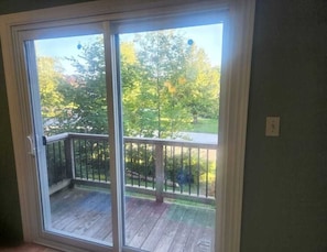 Una habitación con puerta corrediza de vidrio que da a una terraza al aire libre.