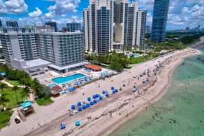 A high-rise hotel with a pool area, beach, and ocean view. - Stylish Ocean view/front Studio + Pool (Sunny Isles Beach)