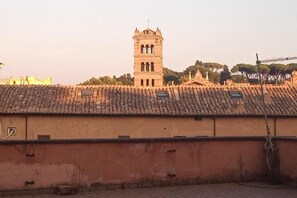 A building with a tiled roof and a tower with arched windows. - BQA San Crisogono Apartments Rome-Trastevere (Roma)