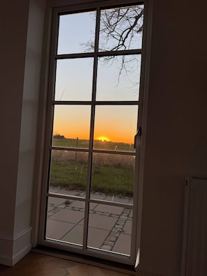 Vista a través de una ventana con cielo despejado y atardecer.