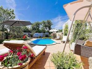 Ein Poolbereich mit Liegestühlen, einem Pool und Sonnenschirmen.