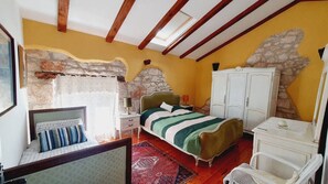 Ein Schlafzimmer mit einem Bett, einem Kleiderschrank, einem Schreibtisch und einem Stuhl.