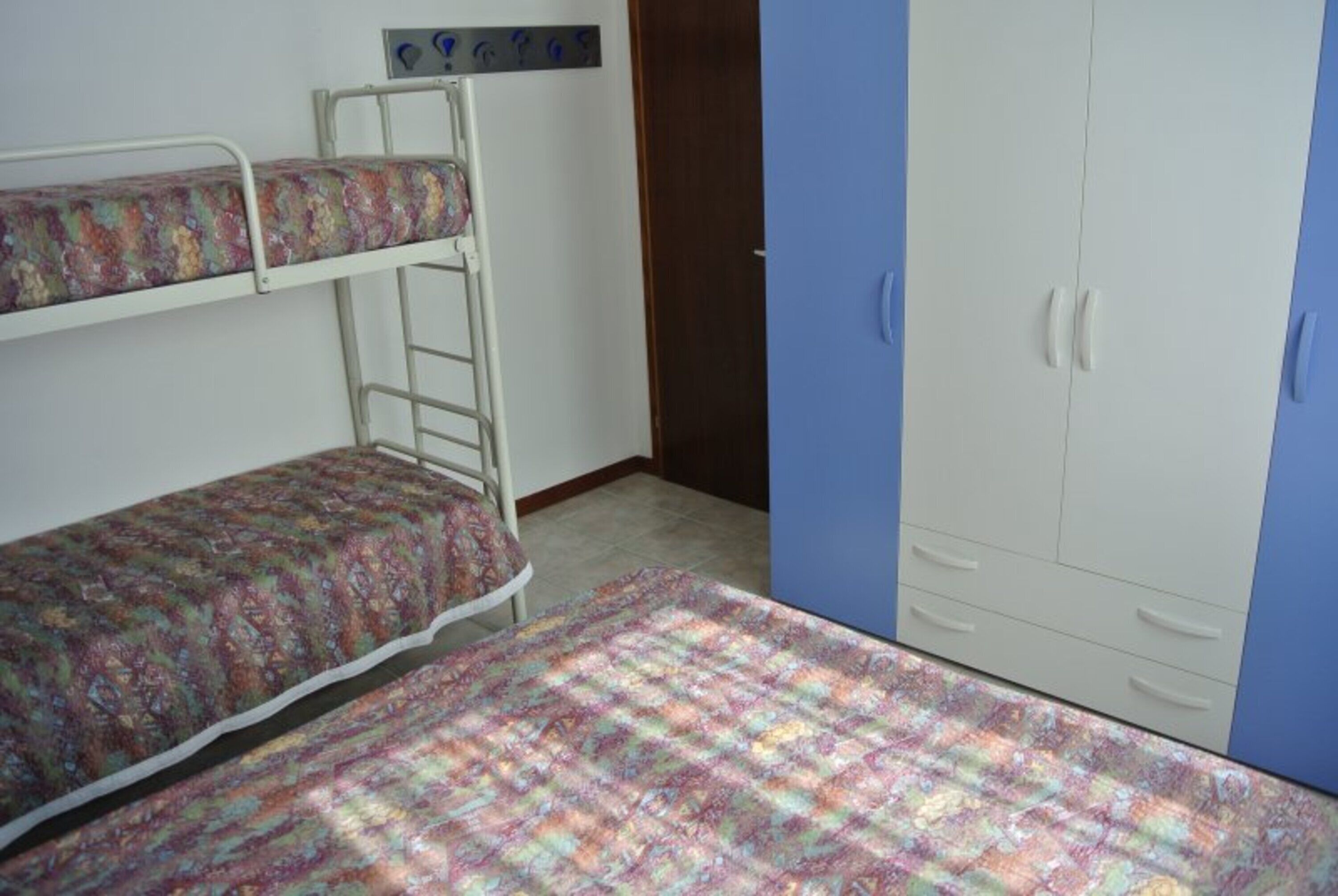 A room with bunk beds, a wardrobe, and a ladder.