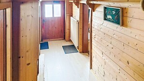 A wooden hallway with a door at the end, a radiator, and a framed picture on the wall.
