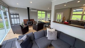 Una sala moderna con un sofá modular, chimenea y comedor.