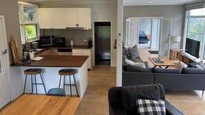 Una cocina moderna con armarios blancos, una isla central y un refrigerador de acero inoxidable.