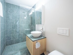 A modern bathroom with a large sink, a mirror, and a shower area. - Cosy apartment for 6 people with WIFI, TV and terrace (Waldhaus)