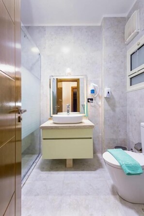 Ein Badezimmer mit Waschbecken, Spiegel und Toilette.