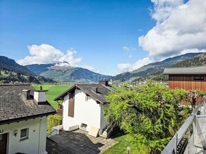 A residential area with houses, a wooden building, and a mountain in the background. - Cosy apartment for 4 guests with WIFI, TV, terrace, pets allowed and panoramic view (Sagogn)