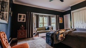 A bedroom with a bed, a sofa, a chair, a window, and a door. - Istana Lodge - 5 Bed house on acreage with pool (Musk Vale)
