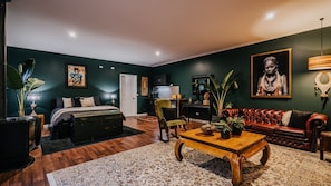 Una habitación con cama, sofá, mesa de centro y escritorio.