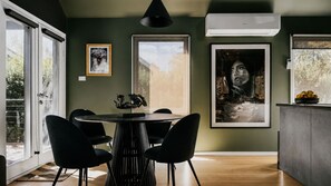 Una cocina moderna con una mesa de comedor, sillas y obras de arte en las paredes.