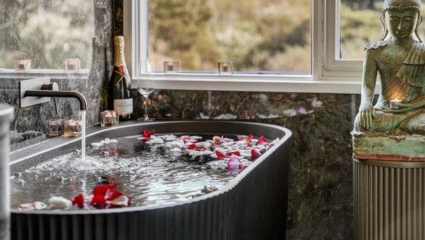 A bathroom with a bathtub, a statue, and a window with a view. - Boatshed Villas by Istana - Yellow Door, villa near Lake Daylesford (Daylesford)