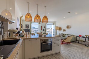 A modern kitchen with an island, built-in oven, and pendant lights. - The "Classé VIP", a balcony perched on the Old Port (La Ciotat)