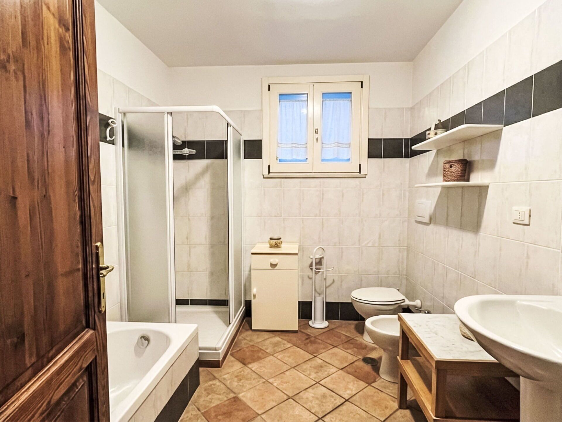 A bathroom with a shower, toilet, sink, and bathtub.