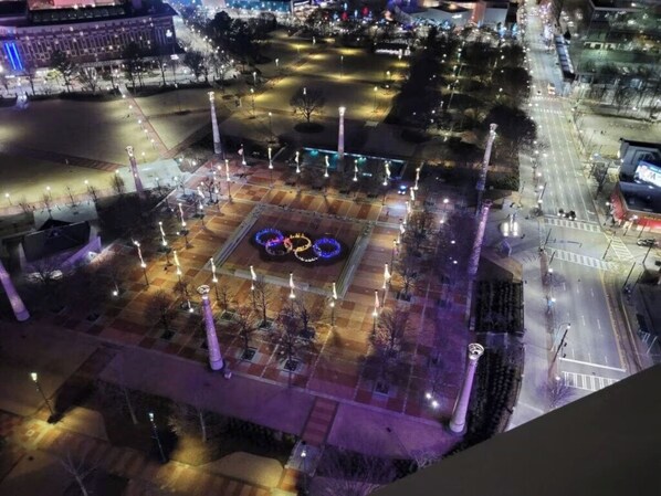 Vista aérea de una plaza con un diseño circular de luces, árboles y una carretera.