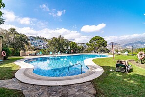 A swimming pool with a curved edge, surrounded by a stone deck. - BVQ - Stunning Sea & Golf View Terrace (Benahavis)