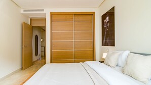 Una camera da letto con un letto grande, un armadio in legno e un'opera d'arte appesa al muro.