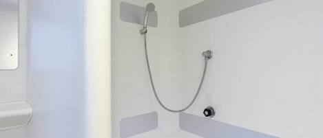 Une douche équipée d’un pommeau de douche à main et d’un robinet fixé au mur.
