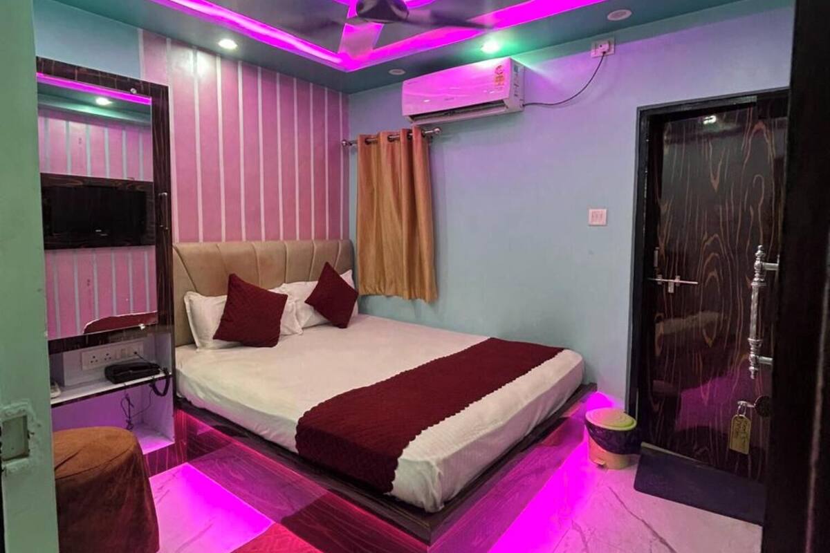 Un dormitorio moderno con cama, ventilador de techo, equipo de aire acondicionado y una puerta.