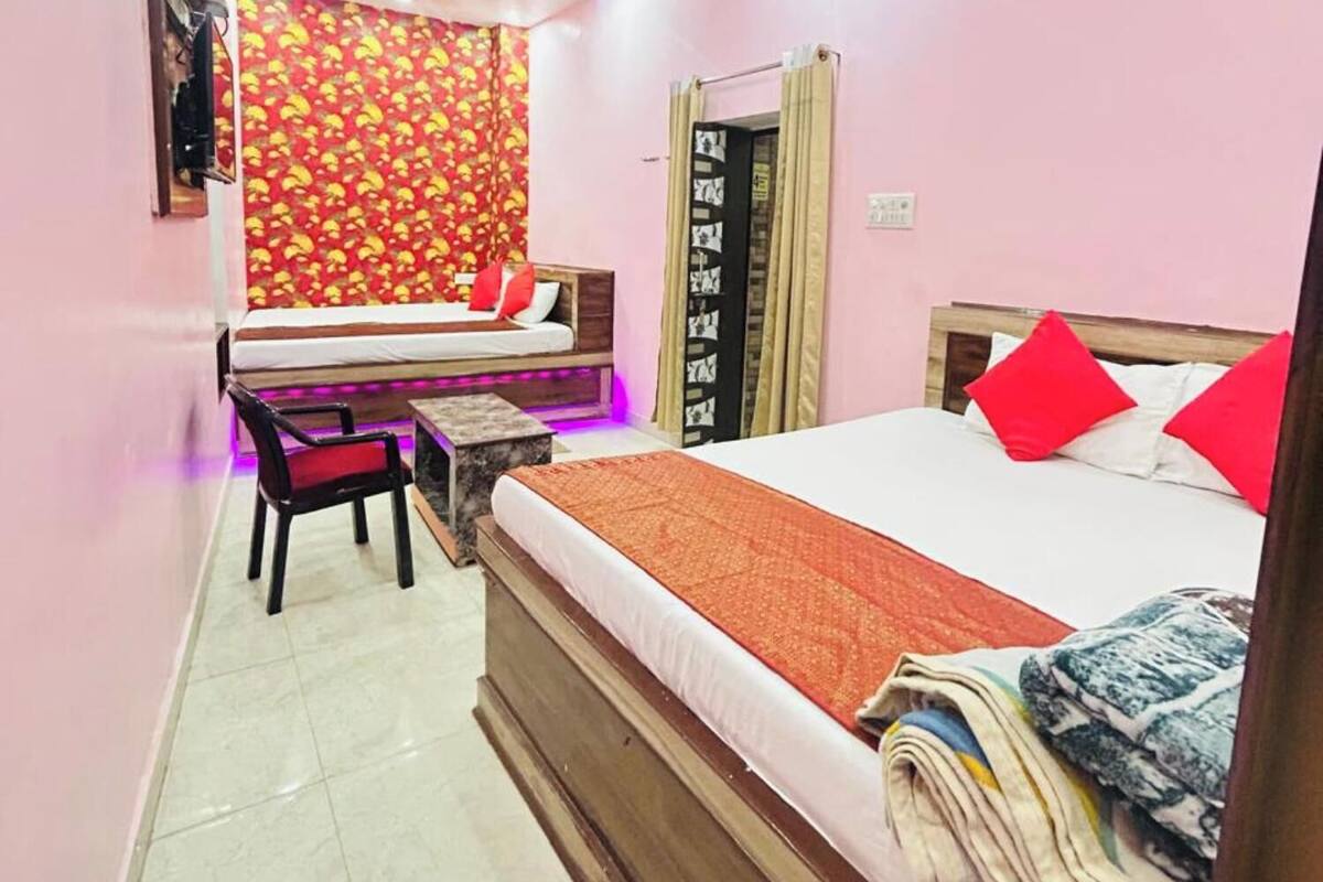 Un dormitorio con cama, escritorio, silla y ventana con cortinas.