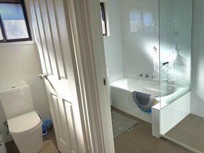 Un baño con inodoro, bañera y zona de ducha.