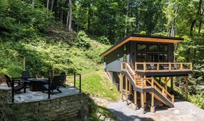 A cabin with a deck, outdoor seating, and a fire pit. - The Acosta (Maggie Valley)