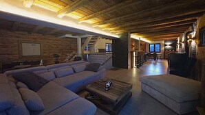 Een moderne woonkamer met een hoekbank, een salontafel en een eethoek met stoelen.