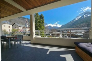 A balcony with a view of mountains and a church.