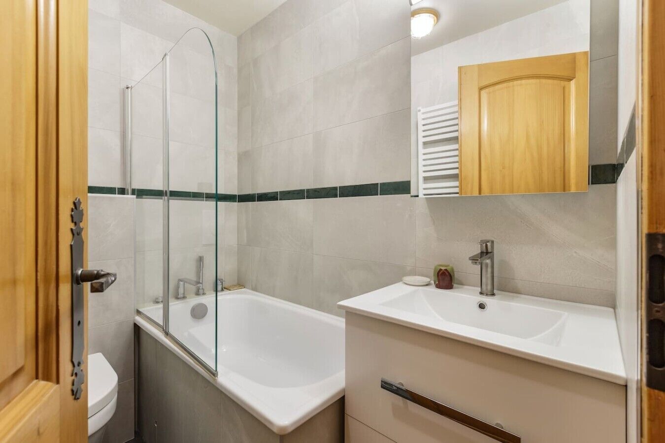 Un baño con cabina de ducha de vidrio, bañera, lavabo y espejo sobre el lavabo.
