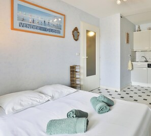 Ein Hotelzimmer mit Bett, Bad mit Waschbecken und einem gerahmten Bild an der Wand.